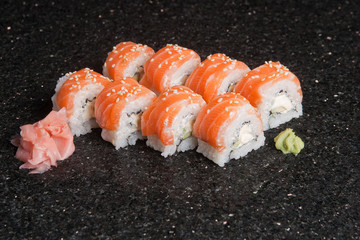 Sushi rolls on black marble background. Fresh Hosomak, Maki, Nigiri, Tempura, Uramaki, Philadelphia pieces with rice, nori and fish. Japanese cusine, Asian food.