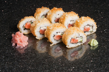 Sushi rolls on black marble background. Fresh Hosomak, Maki, Nigiri, Tempura, Uramaki, Philadelphia pieces with rice, nori and fish. Japanese cusine, Asian food.
