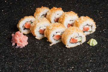 Sushi rolls on black marble background. Fresh Hosomak, Maki, Nigiri, Tempura, Uramaki, Philadelphia pieces with rice, nori and fish. Japanese cusine, Asian food.
