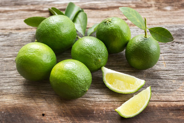 Fresh limes on old wooden background. With dark vignette. Favorite vegetable for sour taste.