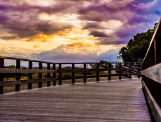 Obraz premium wooden walkway with amaziung sunset on the promenade of marbella on the costa del sol