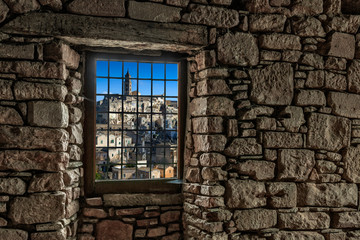 Fototapeta na wymiar Looking through a window in a stone wall to Matera