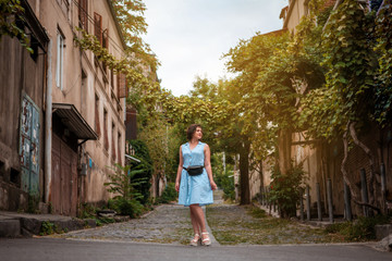 Fototapeta na wymiar a girl in a blue dress walking around the old town