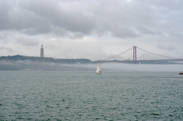 25th of April Suspension Bridge over the Tagus river in Lisbon, Portugal Havy rainy clouds and fog at Ponte 25 de Abril, Lisboa, Portugal