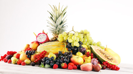 Naklejka na ściany i meble Tropical fruits background, many colorful ripe fruits with strawberries, grapes and cherries on wooden background