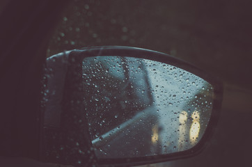 bad weather on the road in the car mirror