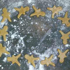 Female hands in flour making Christmas cookie in the form of gingerbread man from dough in kitchen. Home baking process
