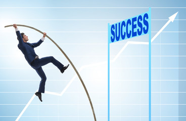 Businessman pole vaulting over towards his success career