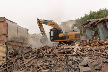 Dismantling (demolition) of an old, dilapidated residential building. Excavator demolishes a house...