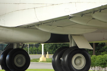 Rear wheels and landing gear under airplane wing, chassis of passenger aircraft close up