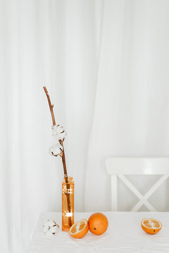 Oranges in composition with flower in vase