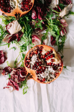 Colorful pomegranate with greens in arrangement
