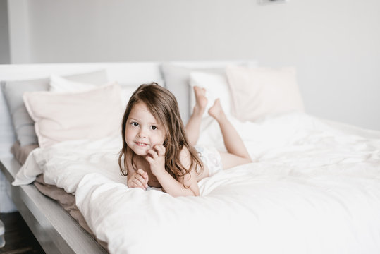 Charming little girl lying on bed