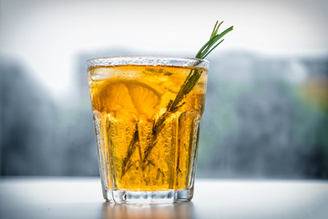 alcoholic drink with lemon and rosemary on a white background