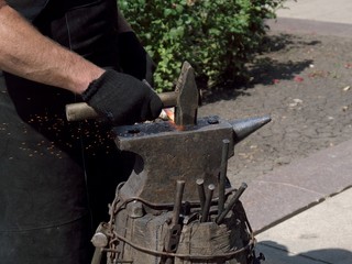  The photo of the hands of a blacksmith forging iron