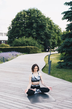 Woman meditating on pathway in park