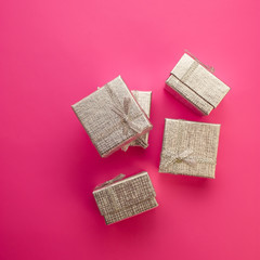 Christmas Festive Background. Silver Gift Boxes on a Pink Background.