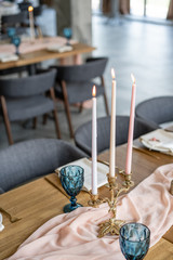 luxury dinner Banquet in the restaurant. Beautiful and exquisite decoration of the wedding celebration. Banquet served table with a beige pink tablecloth, plates and candlesticks with candles.
