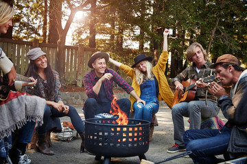 Group of friends camping around fire