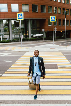 Black man with suitcase on crosswalk