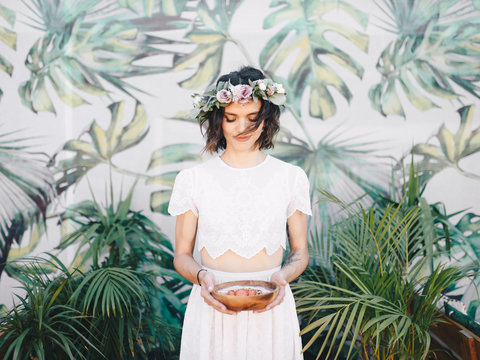 Young woman in dress holding bowl with fruit cake