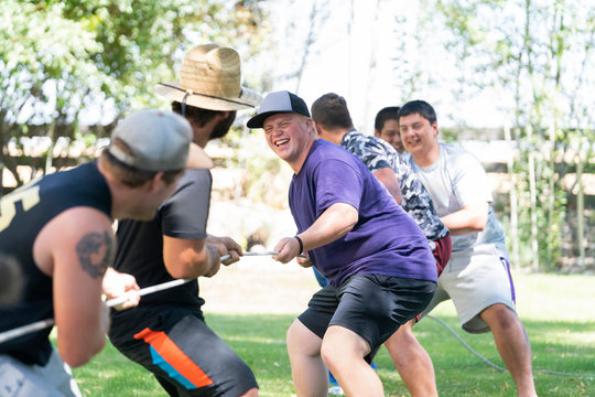 Young teammates playing tug-of-war on the lawn