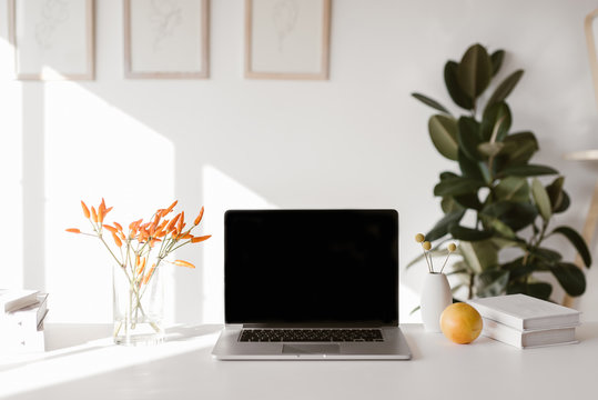 Laptop and flowers on table