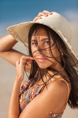 Portrait fashion of pretty young woman with straw hat on a beach. Happy Smiling girl..