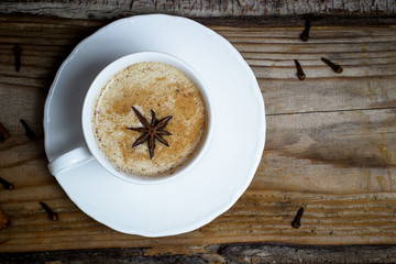 Indian masala chai tea. Spiced tea with milk on dark wooden table. Selective focus, horizontal with copy space.Sunlight.