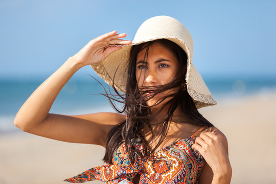 Portrait fashion of pretty young woman with straw hat on a beach. Happy Smiling girl..