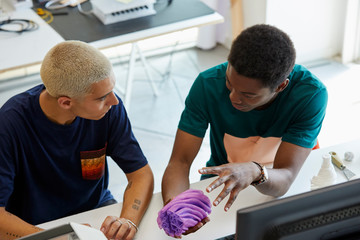 Friends Discussing Over 3D Model At Desk