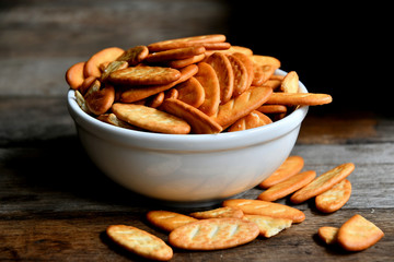 Cracker cookies in a white ceramic bowl on a wooden table.Cracker cookies in a white ceramic bowl on a wooden table.