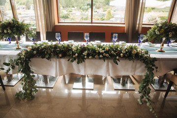 Decorated table for wedding celebration. Bright restaurand with a lot of windows
