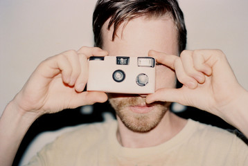 Young man with disposable camera