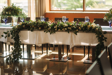 Decorated table for wedding celebration. Bright restaurand with a lot of windows