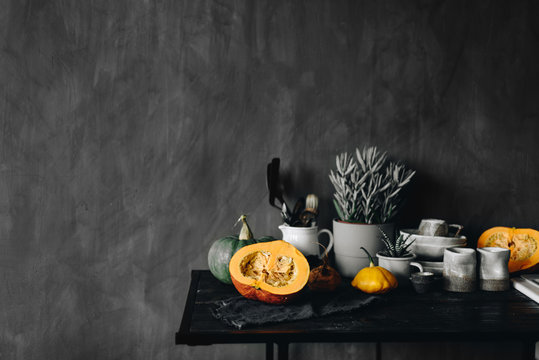 Table with dishware and pumpkins