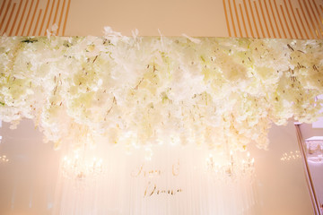 Floral elements of roof. Decorated chandelier on wedding