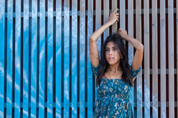 Fototapeta na wymiar Pretty young woman leaning against a wooden fence..Happy girl enjoying freedom.
