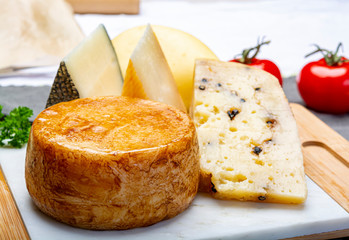 Variety of Italian pecorino cheeses, yellow aged, with black peppers from Nebrodi, white Il Palio and black molarotto, close up