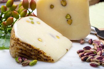 Italian provolone or provola cheese made in Sicily with tasty green Bronte pistachio nuts served on...
