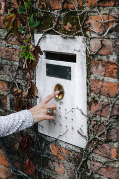 Close up of woman`s hand ringing door bell