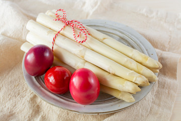 New harvest of white asparagus and colored Easter eggs, high quality raw asparagus in spring season, ingredients for Easter dinner