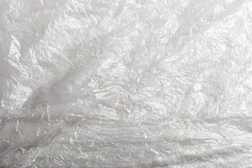 Crumpled plastic transparent bag background. Texture of a transparent plastic bag on white. Abstract plastic sheet texture.