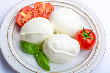 Italian soft cheese mozzarella, white cheese made from cow or buffalo milk with fresh green basil herb and red tomato