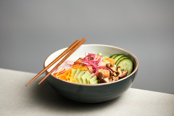 Bowl of rice with vegetables and fish.