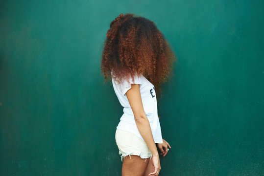 Photo of young afro woman standing against of green background