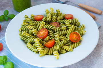 Italian pasta fusilli with green pesto sauce and Parmesan. Horizontal orientation.