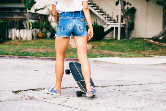 Anonymous Young Sporty Woman Skateboarding in Venice Residential Neighborhood