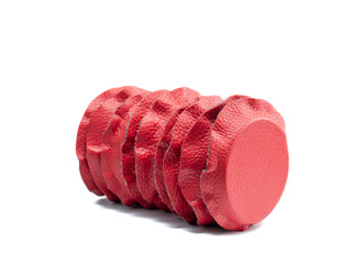 Row of isolated circular magnets lined in red and black leather lying semi inclined for biomagnetism and alternative medicine therapies