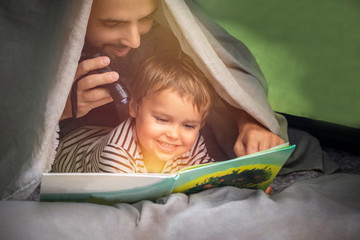 Father's day. Joyful father and son travel together in nature on vacation, camping, in a tent. ...